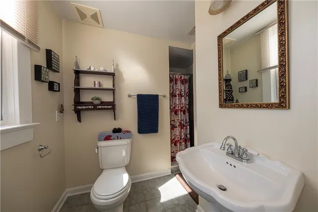 a bathroom with a toilet sink and mirror