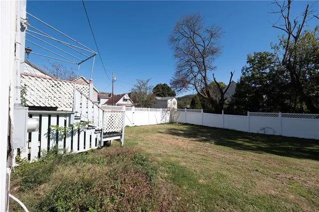 a view of a yard with wooden fence