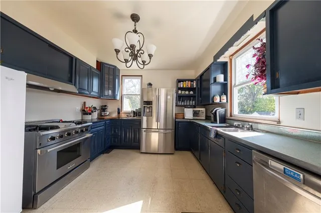 a kitchen with stainless steel appliances granite countertop a large stove a sink dishwasher and a refrigerator with wooden floor