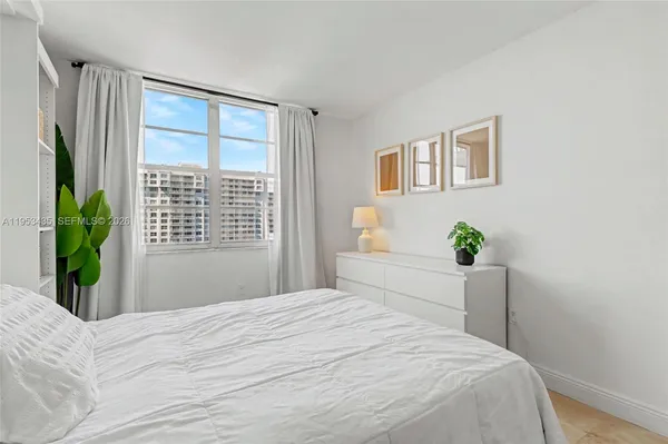 a bedroom with a bed table and a window
