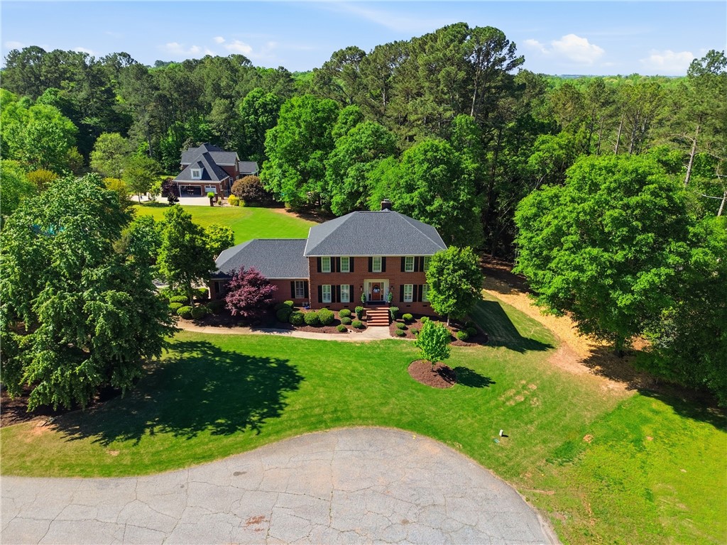 103 5 Knoll Court Anderson, SC 29621 - Photo 30 of 33 A classic brick residence sits on a generous lot amidst lush, mature trees, offering ample green space.