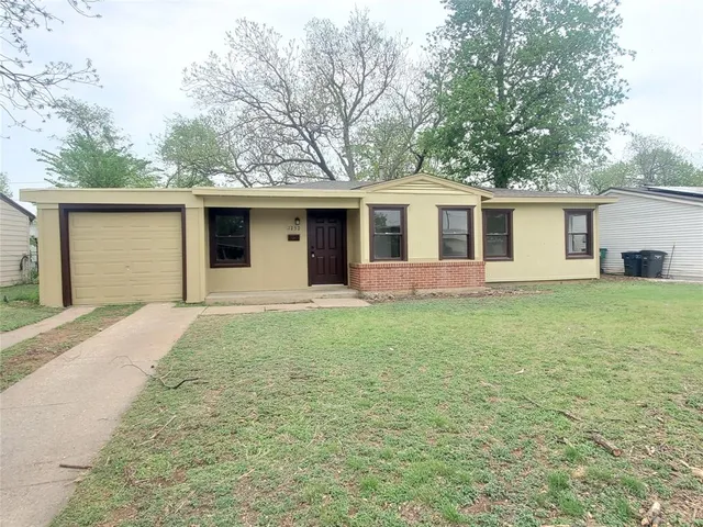 a front view of house with yard and trees all around