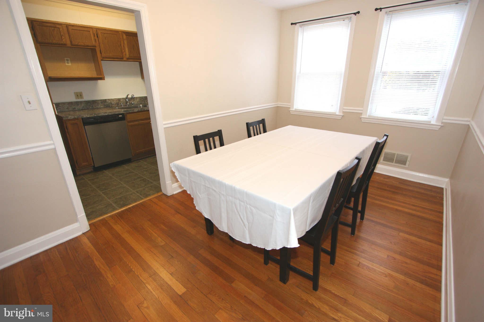 1606 Aberdeen Road Towson, MD 21286 - Photo 8 of 30 a kitchen with a wooden floor and chairs