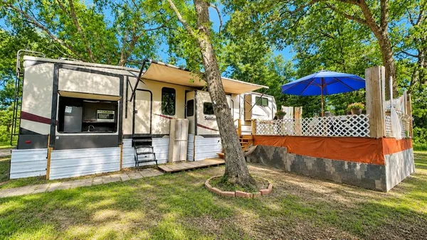 a view of a house with backyard and a tree