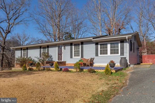 a backyard of a house with yard table and chairs