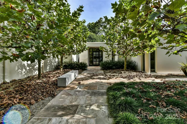 a view of a house with a yard and large tree