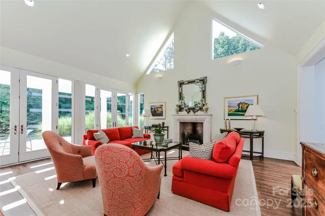 a living room with furniture fireplace and a large window