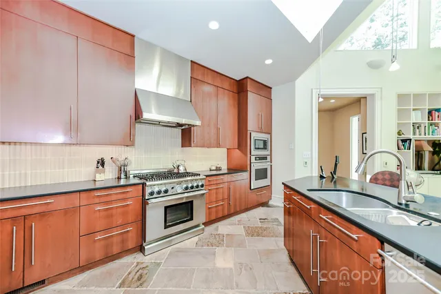 a kitchen with stainless steel appliances granite countertop a sink stove and cabinets