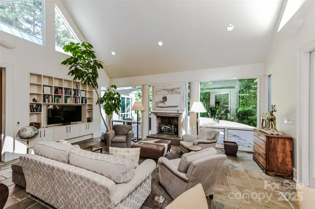a living room with furniture a large window and a fireplace