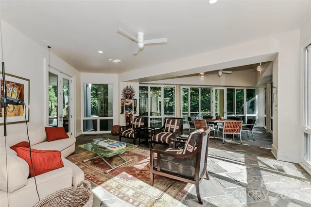 a living room with furniture and large windows