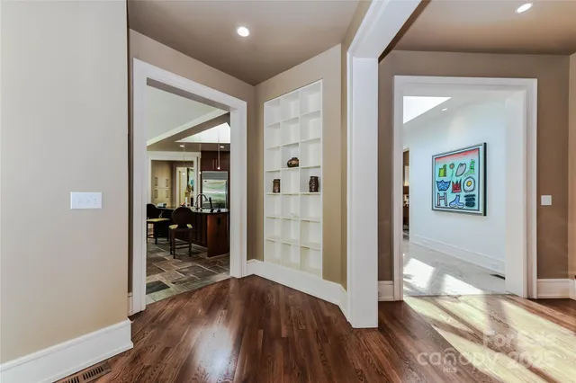a hallway with wooden floor table and chairs