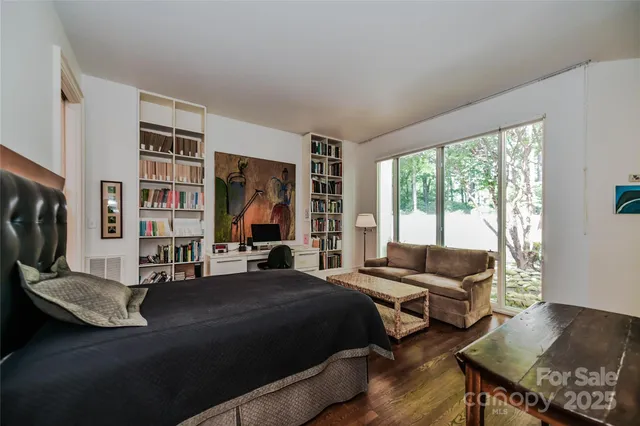 a bedroom with a bed couch and a large window
