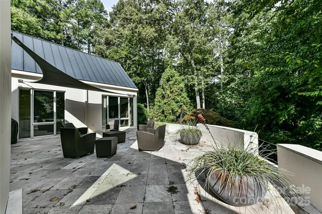a view of a patio with couches table and chairs and potted plants