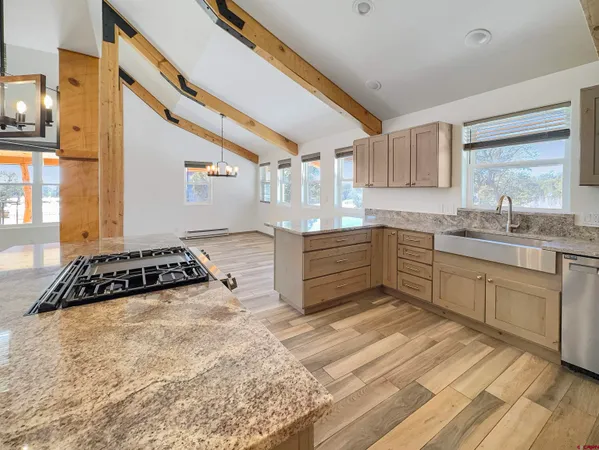 a kitchen with stainless steel appliances granite countertop a sink stove and cabinets