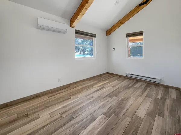 a view of empty room with wooden floor