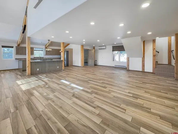 a view of a big room with wooden floor and windows