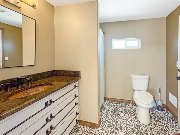 a view of small space in front of a house with large trees