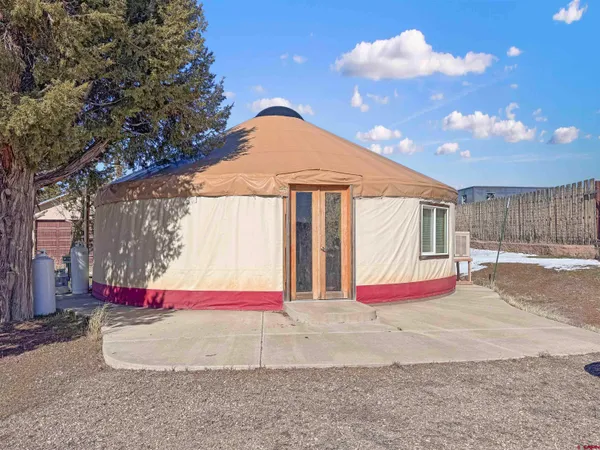 a view of a dry yard with wooden fence