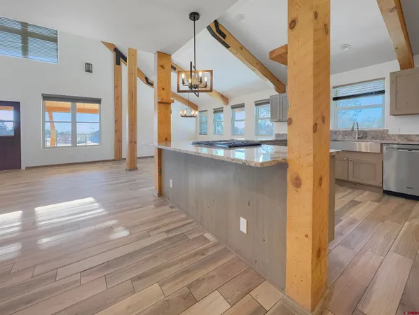 a open kitchen with a sink and dishwasher with wooden floor