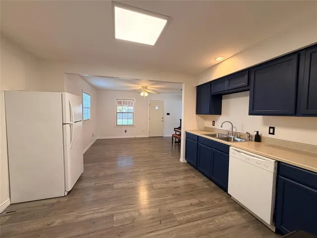 a large kitchen with a refrigerator and a stove top oven
