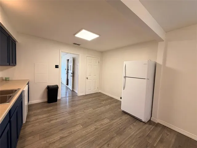 a view of a kitchen with wooden floor and electronic appliances
