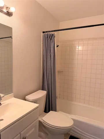 a white toilet sitting next to a bath tub