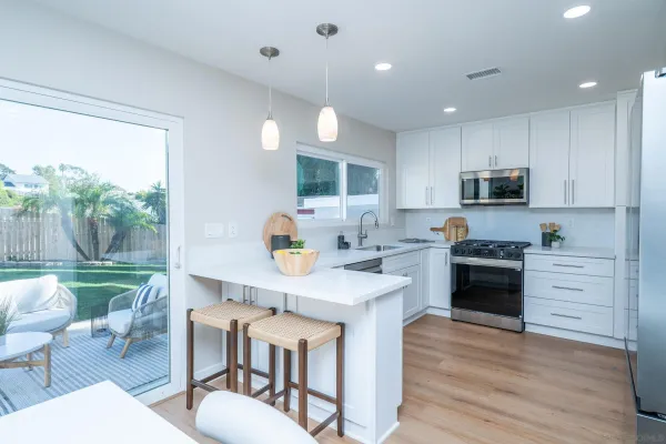 a view of a patio with couches and a table and chairs with wooden floor