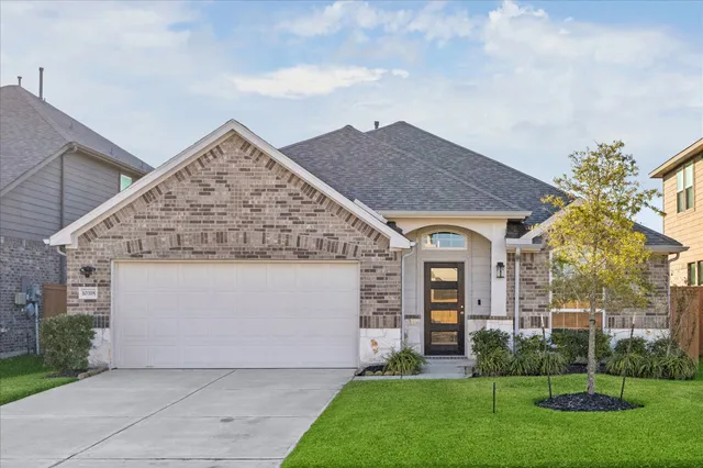 a front view of a house with a garden and plants