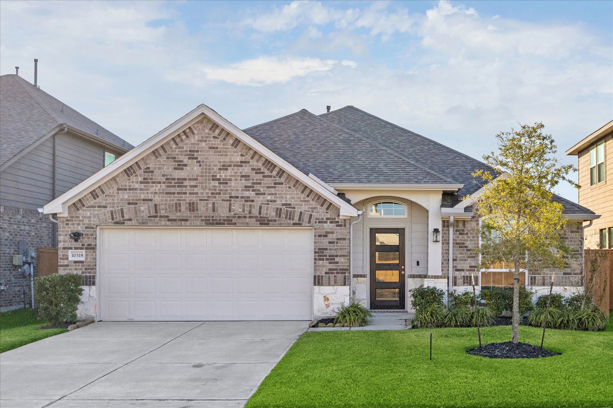 a front view of a house with a garden and plants