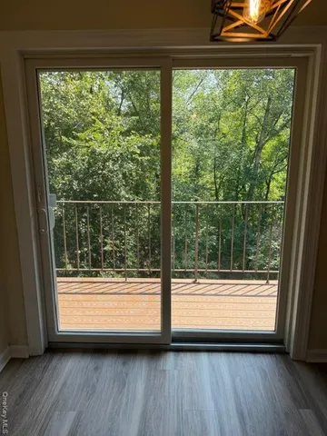 a view of a room with wooden floor and a bathroom