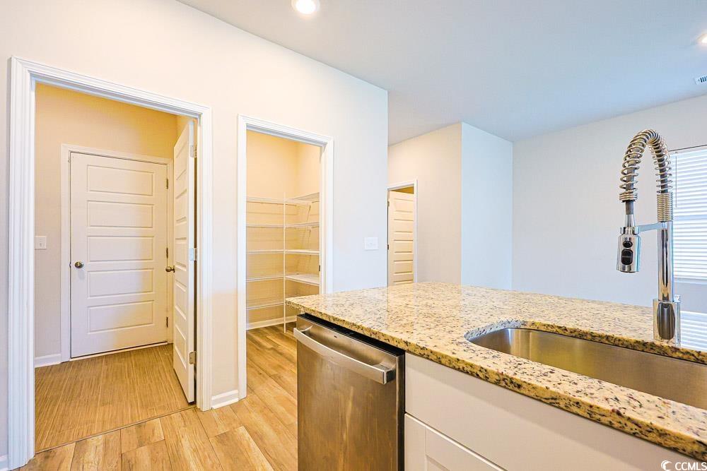1560 Swing Bridge Way Myrtle Beach, SC 29588 - Photo 6 of 35 Kitchen with light wood-style flooring, stainless steel dishwasher, light stone countertops, white cabinets, and recessed lighting
