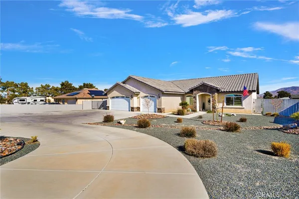 a front view of a house with cars parked