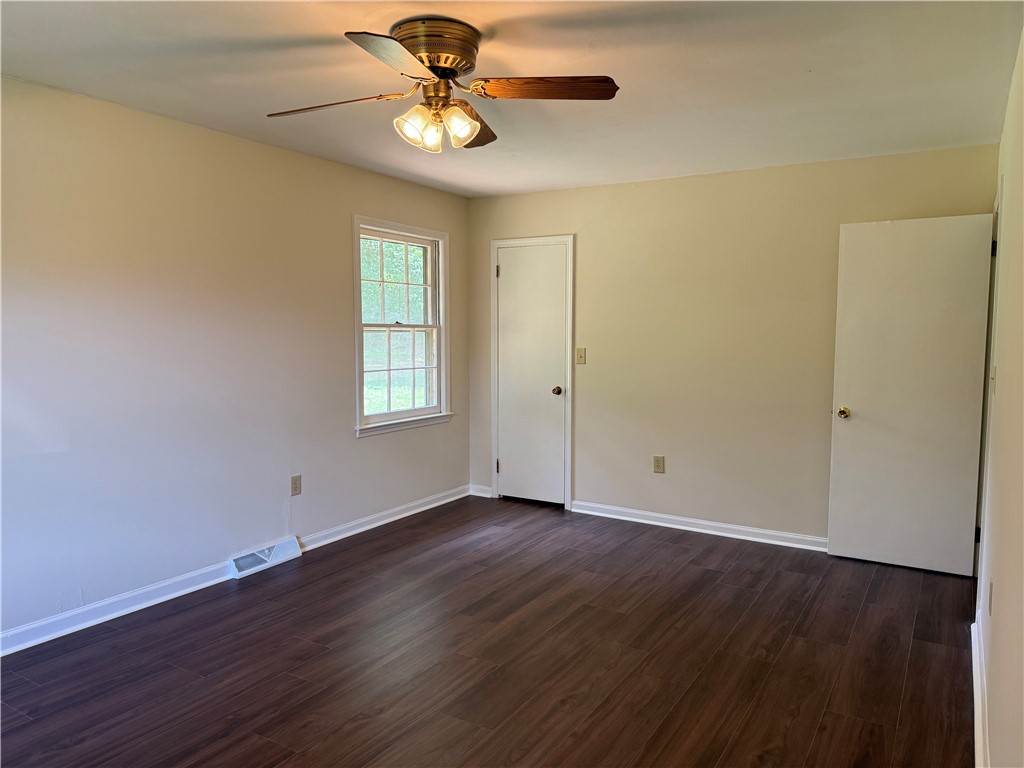 1507 East Calhoun Street Anderson, SC 29621 - Photo 12 of 18 Well-lit sleeping quarters with a ceiling fan, durable flooring, and ample natural light.