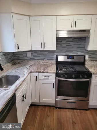 a kitchen with granite countertop a stove and a sink