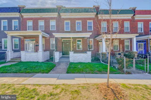 a front view of a brick house with a yard