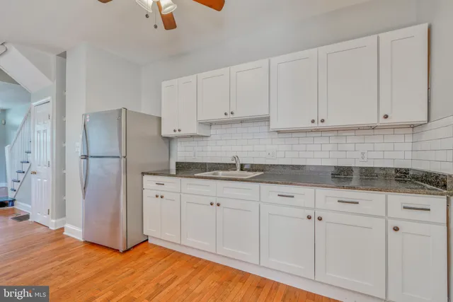a kitchen with granite countertop white cabinets white stainless steel appliances and sink
