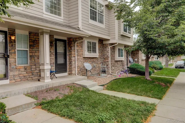 a front view of a house with yard and green space