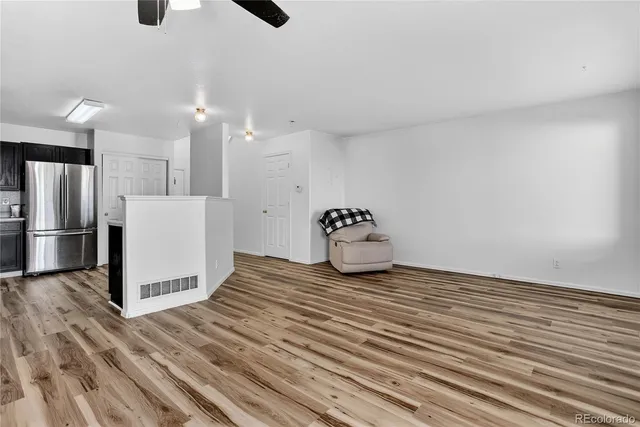 a kitchen with granite countertop white cabinets and refrigerator