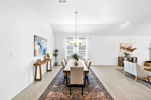 a dining room with furniture a chandelier and window