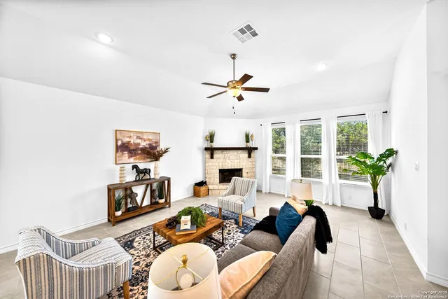 a living room with furniture a fireplace and a chandelier