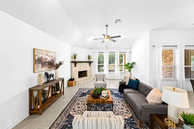 a living room with furniture a flat screen tv and a chandelier