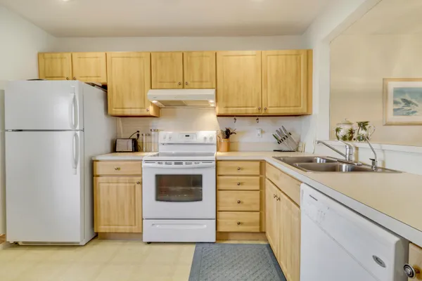 a kitchen with a refrigerator sink and cabinets