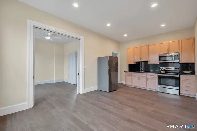 a kitchen with stainless steel appliances granite countertop a refrigerator and a stove top oven