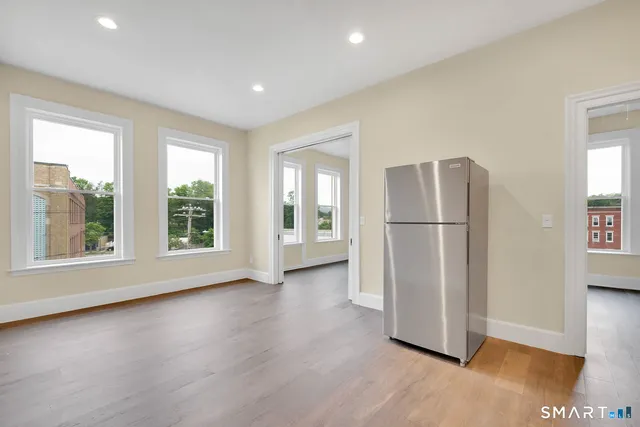 a view of a kitchen with refrigerator and wooden floor