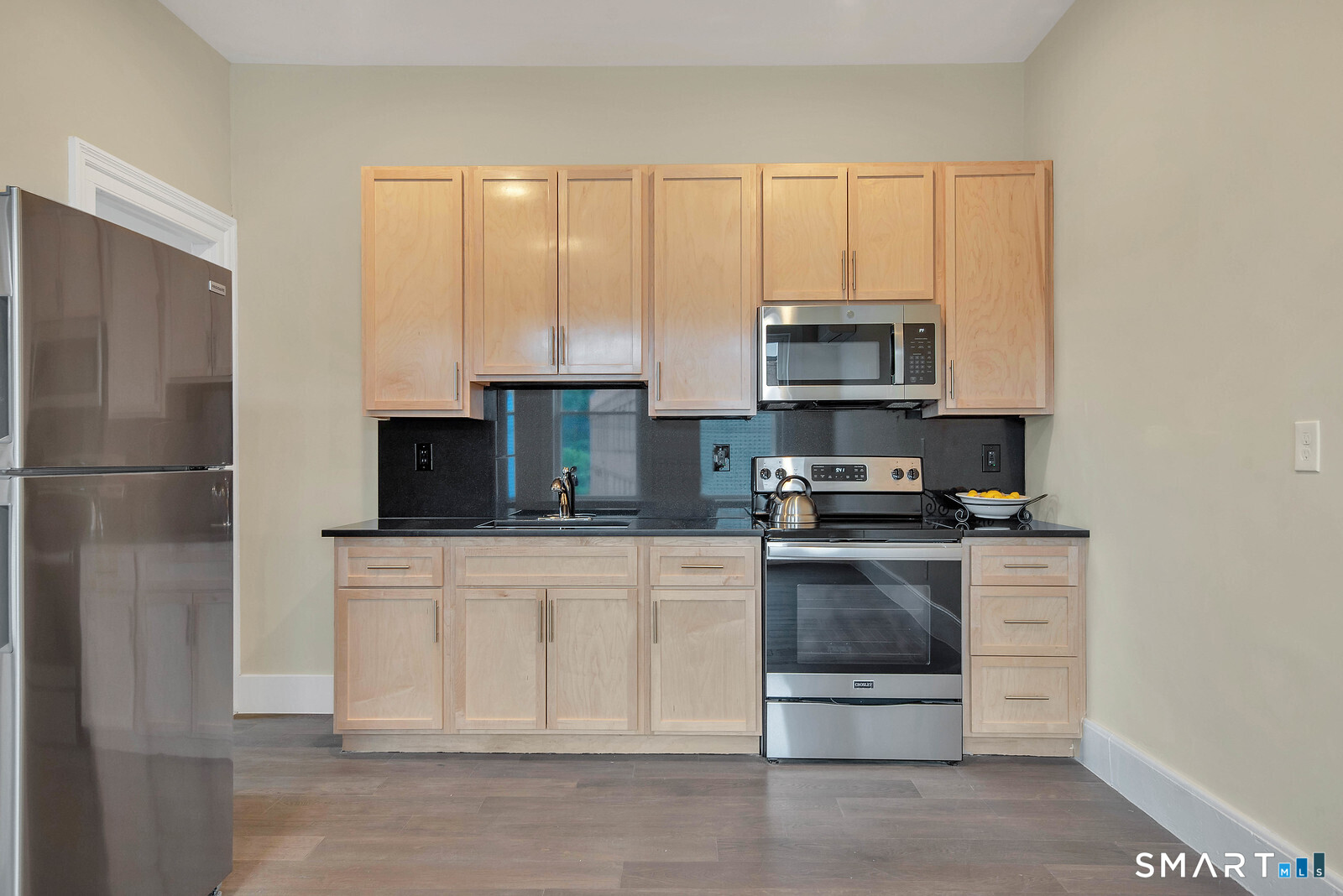 120 East Main Street, Unit 5 Torrington, CT 06790 - Photo 6 of 10 a kitchen with stainless steel appliances granite countertop a stove a microwave and a refrigerator