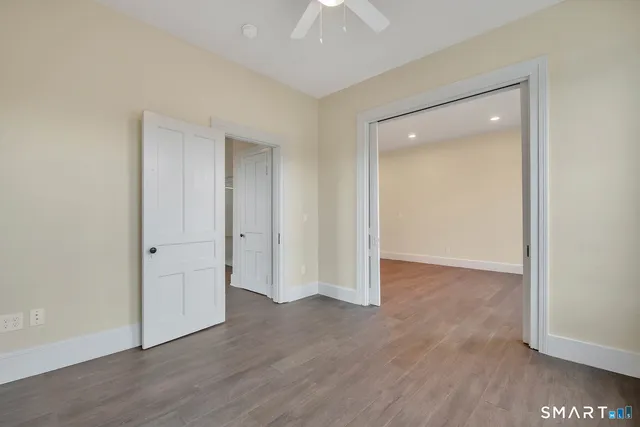 an empty room with wooden floor and closet area