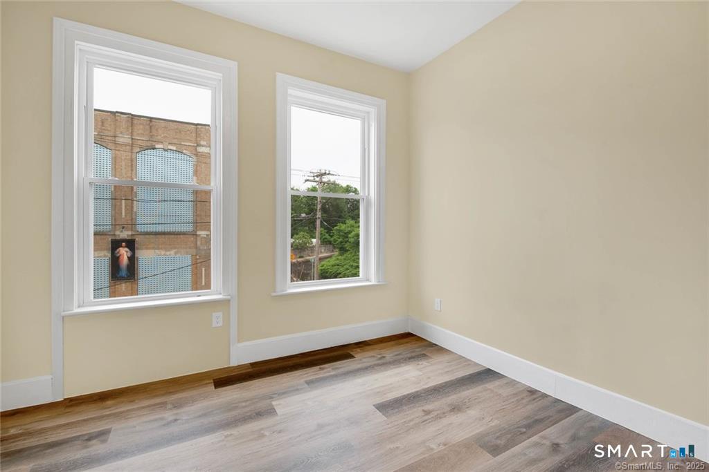 120 East Main Street, Unit 5 Torrington, CT 06790 - Photo 8 of 10 an empty room with wooden floor and windows