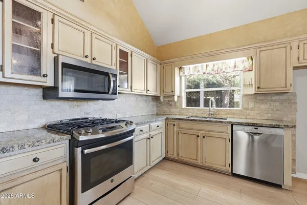 a kitchen with stainless steel appliances granite countertop a stove microwave and sink