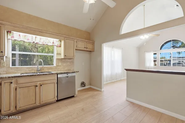 a kitchen with a sink a window and cabinets
