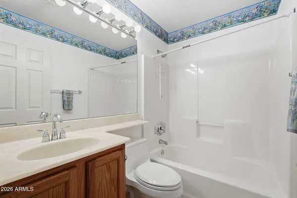 a bathroom with a granite countertop sink a toilet a mirror and shower